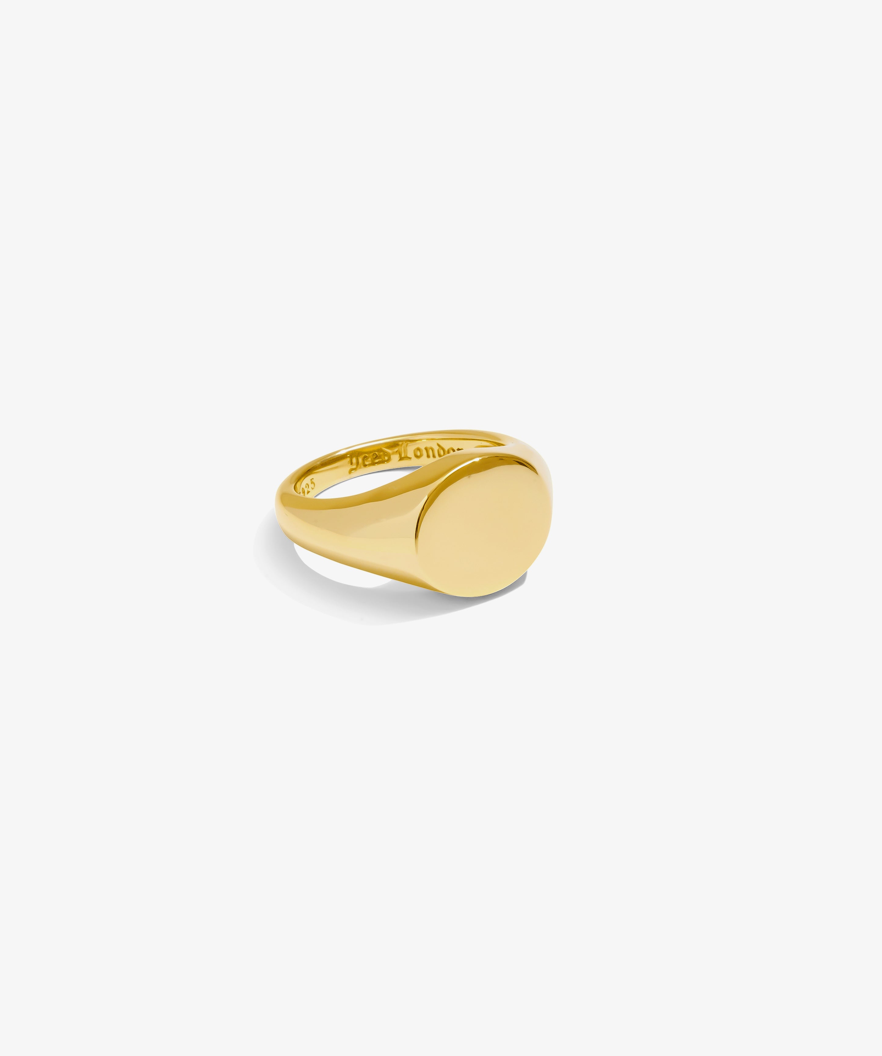 ICED London gold signet ring with smooth oval face, polished band, close-up product shot.
